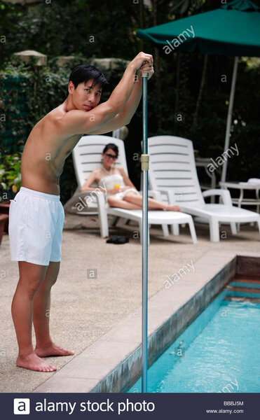 young-man-cleaning-swimming-pool-BBBJ5M