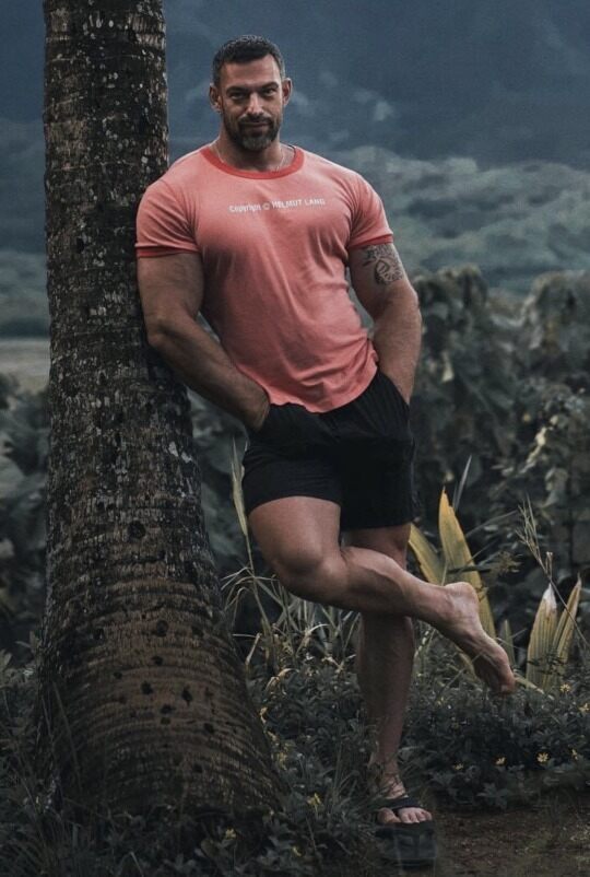 A big hunk leaning against a big trunk.