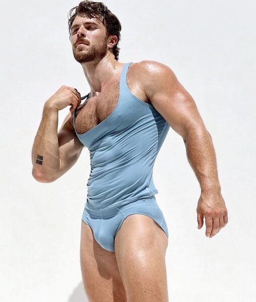 That steel blue low rise tank top nicely accentuates his chest of steel